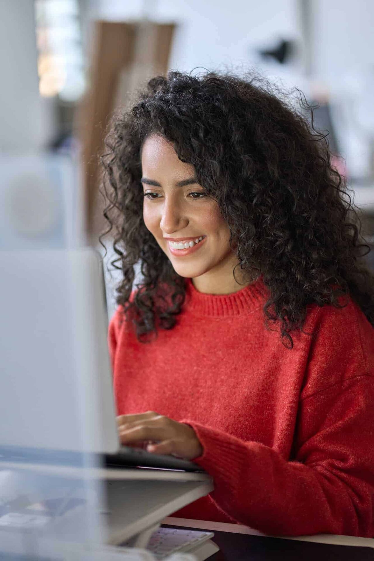 young happy latin woman student elearning using laptop vertical shot.jpg
